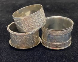 Three assorted hallmarked silver napkin rings, 85g in total