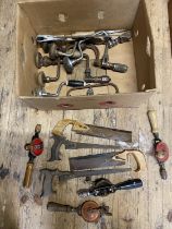 A box full of vintage tools including hand drills and antique saws, shipping unavailable