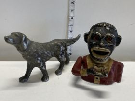 A vintage cast iron money box and contents of coins and a cast metal dog figure