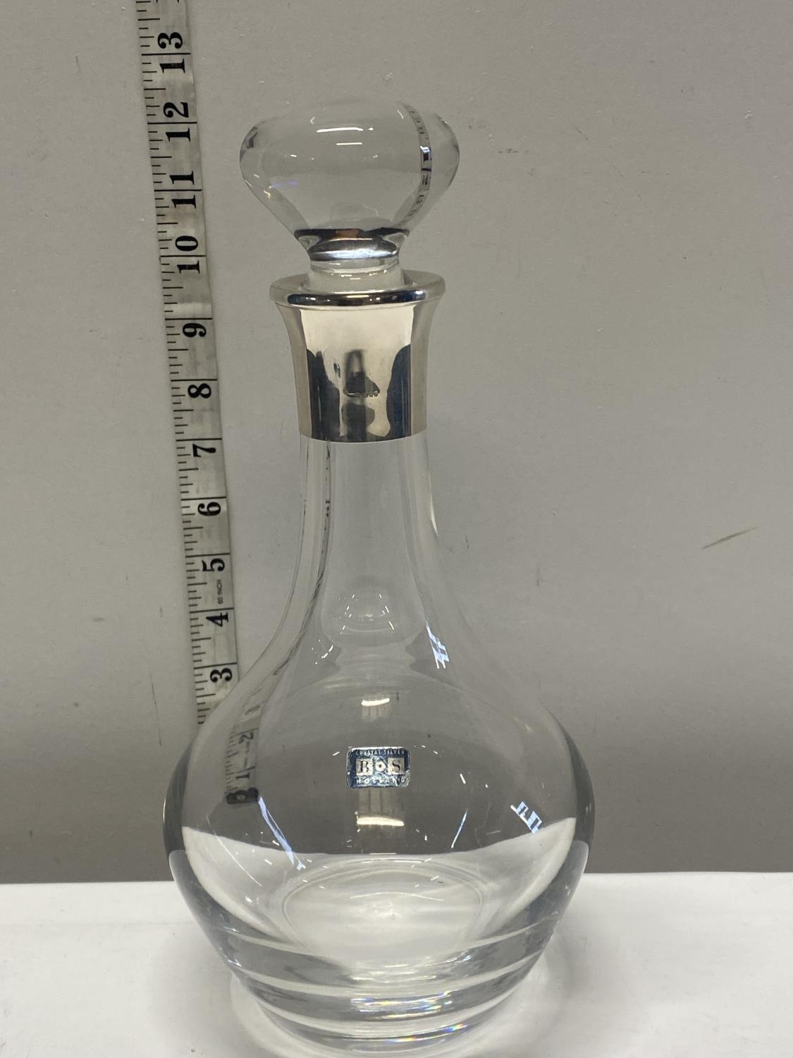 A large cut glass and silver hallmarked rimmed decanter