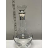 A large cut glass and silver hallmarked rimmed decanter