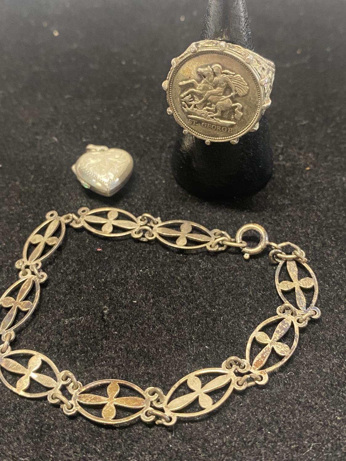 A silver ring, bracelet and locket