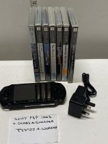 A Sony PSP console with charger and games in working order when tested