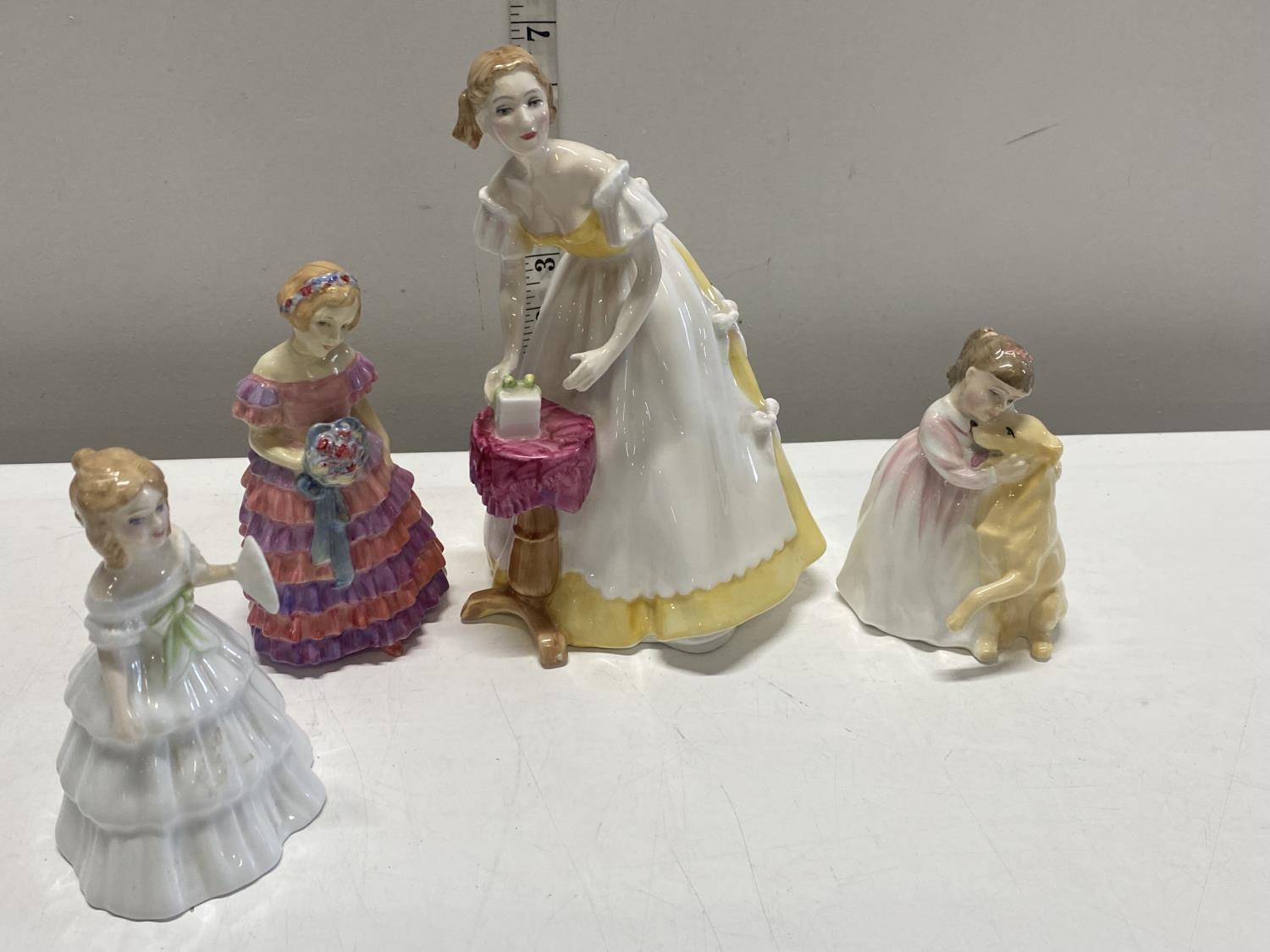 A Royal Doulton lady figurine (2nd quality) and three smaller ones