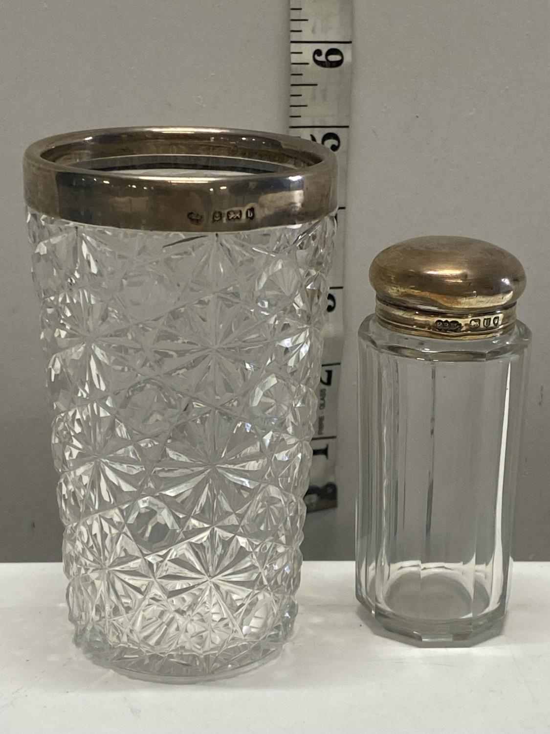 A hallmarked silver topped cut glass beaker and a small silver topped bottle