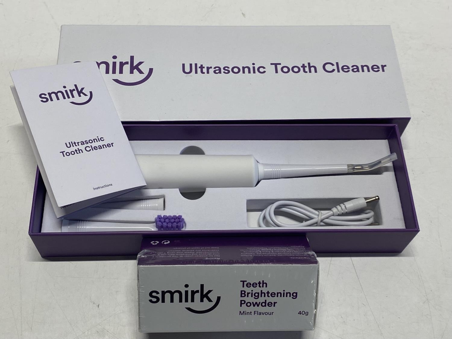 A boxed ultrasonic tooth cleaner and powder (untested)