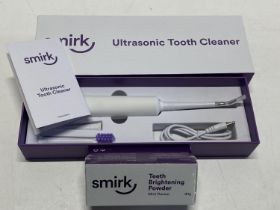 A boxed ultrasonic tooth cleaner and powder (untested)