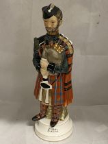 A musical porcelain decanter in the form of a bagpiper, H37cm