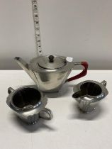A Art Deco period three piece tea service in hand beaten pewter by Warric