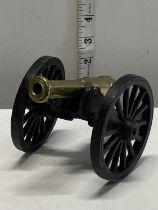 A cast wrought iron and brass canon 20cm long