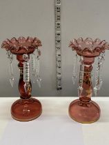 Two early 20th century cranberry glass lustres. (one missing drop) 23cm tall.