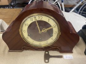 A 1930's wooden cased mantle clock with key & pendulum.