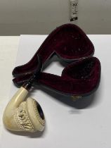 A antique cased Meerschaum with a cherry amber mouth piece