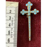 A stick pin in the form of a crucifix with turquoise decoration