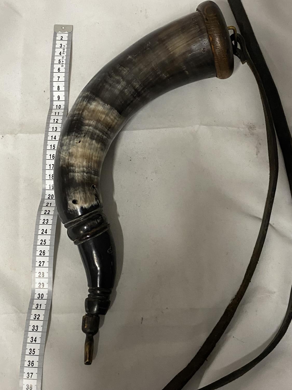 A vintage black powder horn with leather strap (needs re-attaching one end)
