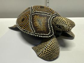 An unusual hand carved wooden turtle with applied decoration. Approx. 30cm long