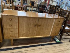 A vintage 1960's Gordon Russell sideboard with eight graduated drawers and central cupboard,