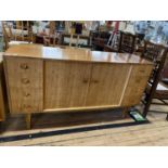 A mid century 1960's Gordon Russell sideboard with eight graduated drawers and central cupboard,