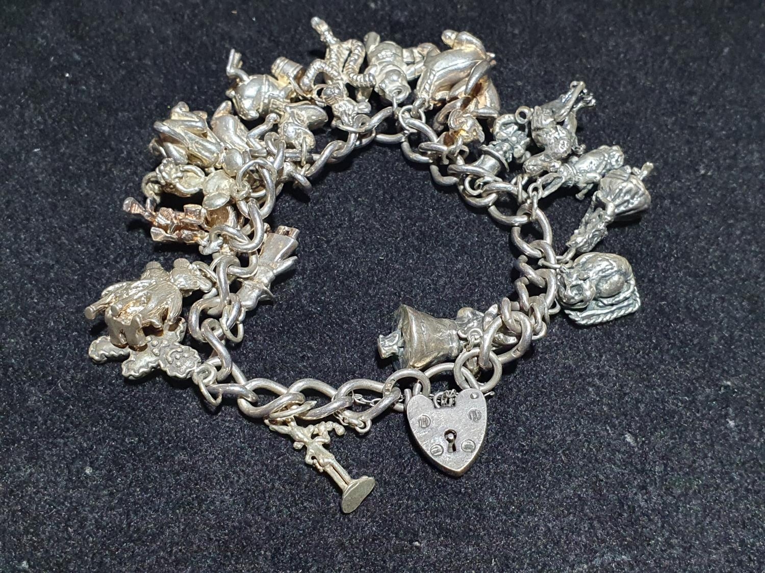 A hallmarked silver bracelet with 925 and white metal charms (Disney themed). Weight 96g