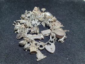 A silver bracelet with 925 and white metal charms (myth and magic themed). Weight 133.74g