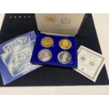 A Sterling silver plated & gold plated four coin set & a 1983 UK UNC coin set.