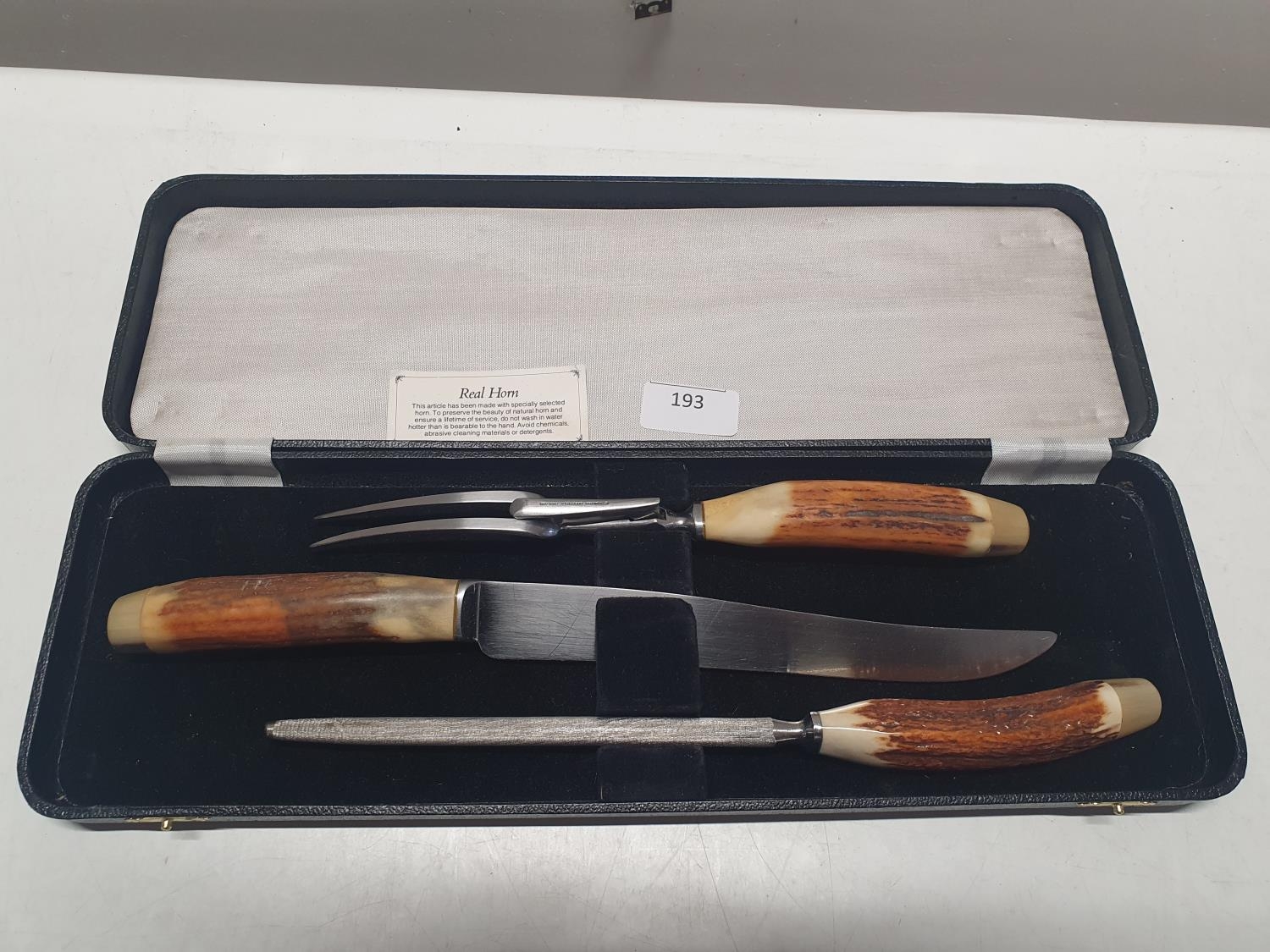 A cased Horn handled carving set. Shipping unavailable