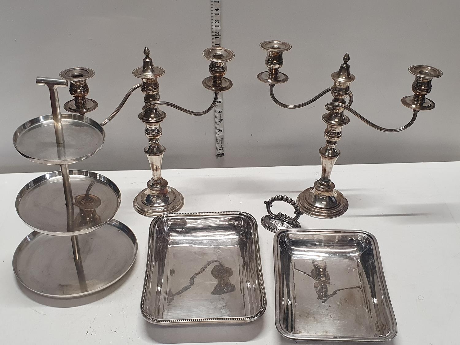 A selection of silver plated wares including candelabras and cake stands. Shipping unavailable