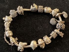 A silver Pandora bracelet with charms gross weight 77.48g