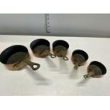 Five antique small graduated copper and brass saucepans