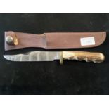 A hunting knife in leather sheath