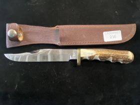 A hunting knife in leather sheath