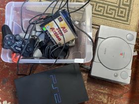 Two games consoles a PS1 and a PS2 with controllers and games (untested)