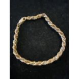 A 18ct gold bracelet entwined with a white metal strand gross weight 7.66g