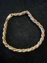 A 18ct gold bracelet entwined with a white metal strand gross weight 7.66g