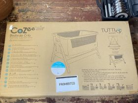 A boxed Cozee bedside crib (unchecked),