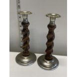 A pair of wooden and white metal candlesticks, shipping unavailable