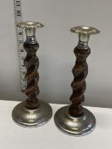 A pair of wooden and white metal candlesticks, shipping unavailable