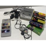 A Super Nintendo games console with assortment of games and controller (untested)