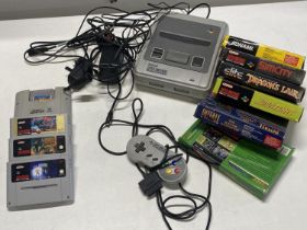 A Super Nintendo games console with assortment of games and controller (untested)