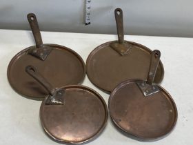 A selection of antique copper sauce pan lids