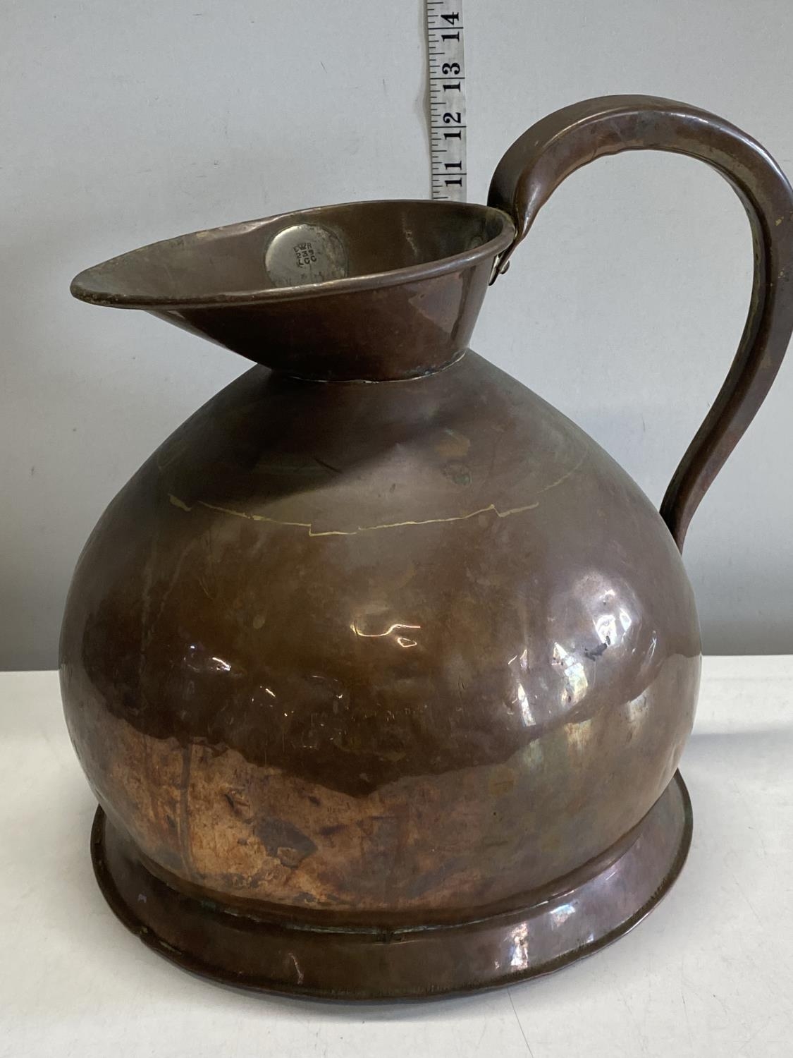 A large heavy copper two gallon jug