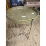 A brass table on foldable legs. shipping unavailable