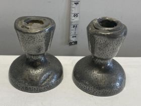 A pair of antique hand planished Tudric pewter candlesticks (a/f)