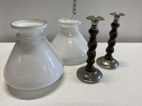A pair of vintage milk glass ceiling shades and a pair of white metal and wooden candle sticks,