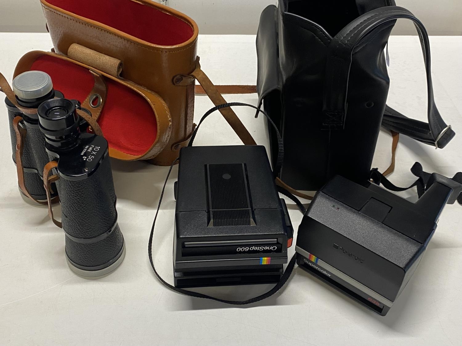 Two vintage Polaroid cameras and a pair of Zenith 10x50 binoculars