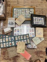 A selection of framed cigarette cards with a selection of albums and loose cards, shipping