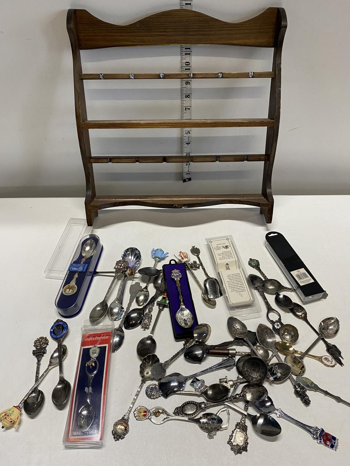 A job lot of assorted collectors spoons and display rack.Shipping unavailable