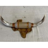 A horn hanging wall plaque in the form of cow horns