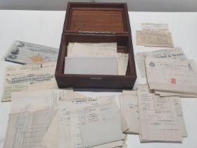 A vintage wooden box with contents of assorted ephemera
