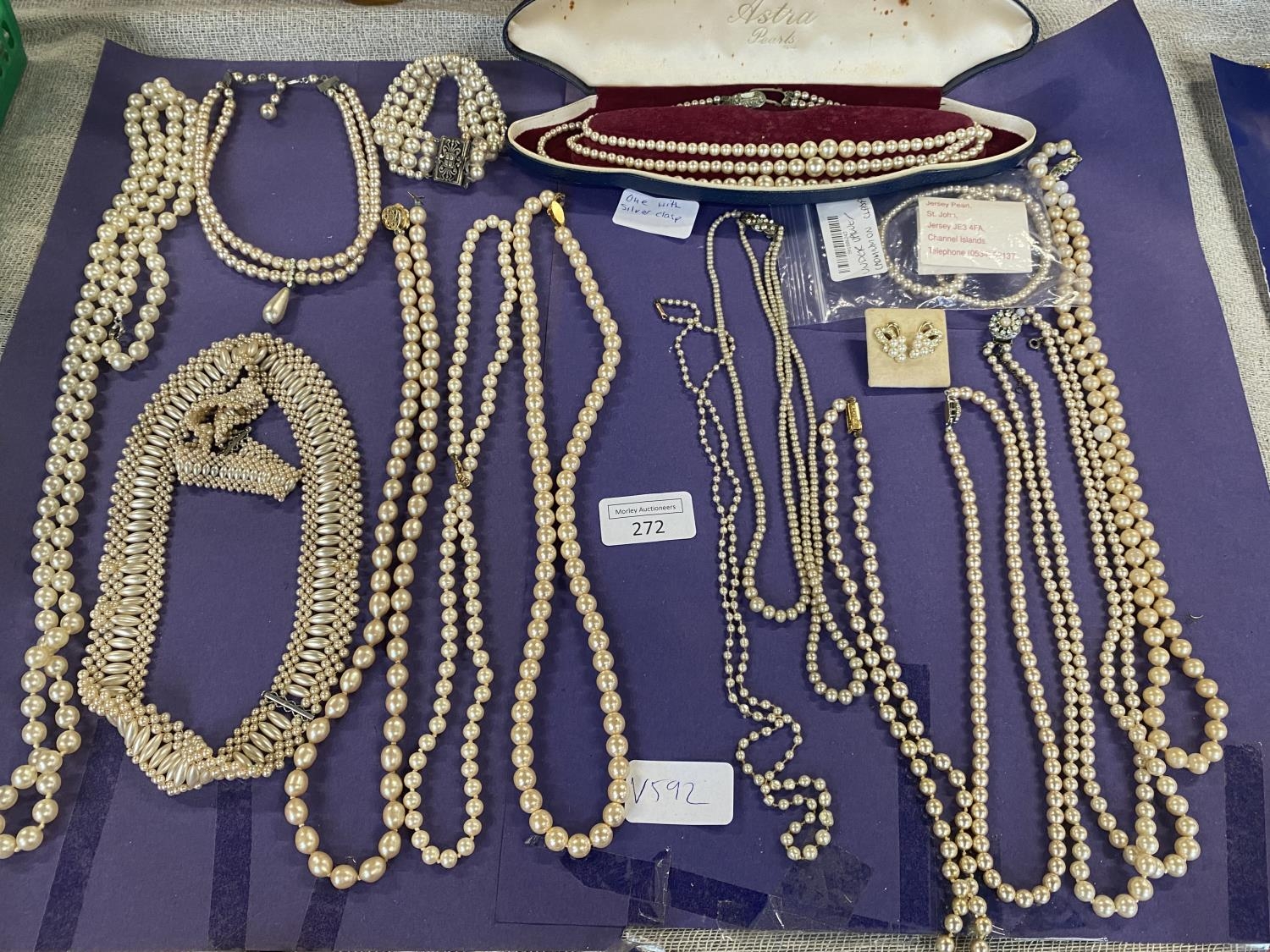 A large collection of assorted simulated pearl necklaces and other